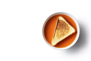 A bowl of creamy tomato soup with a grilled cheese sandwich, top view, on a white background