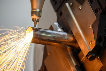 Close up scene the fiber laser cutting machine cut the stainless steel tube and sparkling light.