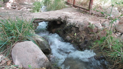 River flowing through a rocky landscape, surrounded by greenery, representing natural beauty and tranquility.