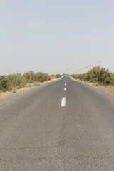 Obraz premium Straight road through desert, symbolizing travel, solitude, and endless journeys in arid environments.