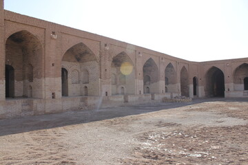 Historic brick corridor with arches in a traditional setting, capturing the architecture and...