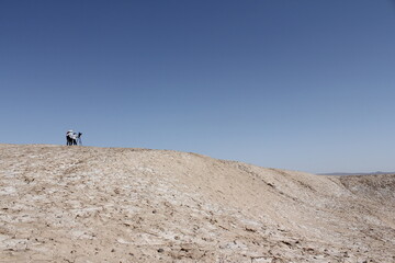 Vast desert landscape under bright blue sky, highlighting the simplicity and beauty of untouched,...