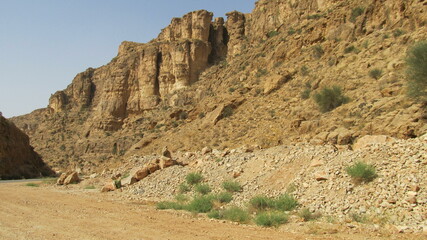 Desert landscape with tall cliffs under a clear sky, capturing the grandeur of natural rock formations.