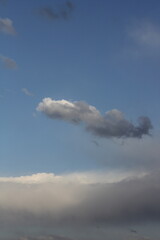 A single cloud floating in blue sky, creating a simple yet captivating scene.