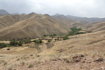 Expansive view of rugged mountain terrain under a clear sky, showcasing remote natural beauty.