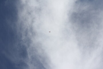 Blue sky with small cloud, contrasting with the rugged desert below, emphasizing vastness and solitude.