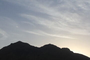 Majestic mountain silhouettes at dusk, creating a captivating natural scene with a serene, peaceful ambiance, perfect for tranquil outdoor themes.