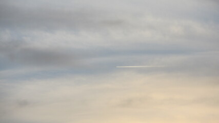 Cloudy sky over an open field, portraying calmness and natural beauty in a rural setting.