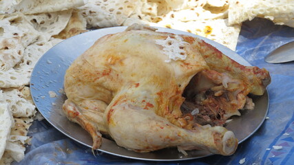 Freshly baked roasted chicken on a plate, representing home-cooked meal with crispy skin and juicy flavor.