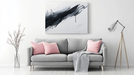 A black and white painting hangs on the wall above a gray couch