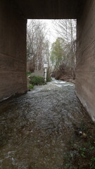 Obraz premium A pathway through an old rustic structure, surrounded by textured walls, leading to a shaded, mysterious interior, evoking timelessness and tradition.