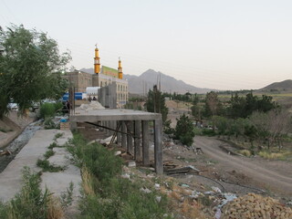 Scenic view of rural landscape with mountains in background, capturing nature's beauty at sunrise or sunset.