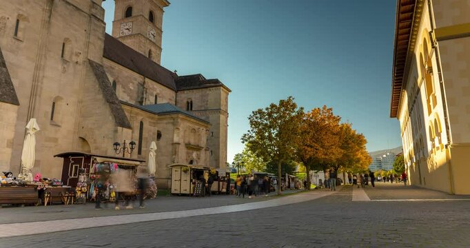 Alba Iulia, Romania - October 20, 2024: Str. Mihai Viteazul street view. Saint Michael Cathedral on the left. Timelapse, slide transition. Clear sky sunny day.