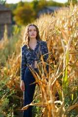 A Fashion Model is Posing Gracefully in a Beautiful Cornfield while Bathed in Natural Light