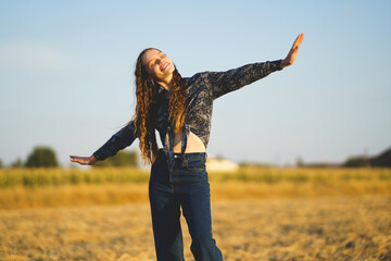 A Joyful Young Woman Dancing Gracefully in a Beautiful Field at Sunset, Radiating Happiness