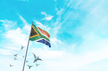 South Africa flag waving with flying doves in beautiful sky. South Africa flag for Republic Day and...