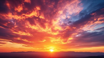 Naklejka premium Vibrant Sunset Over Silhouetted Mountains