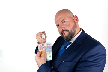 portrait of businessman in blue suit and tie with friendly expression showing a watch and banknotes isolated on white background