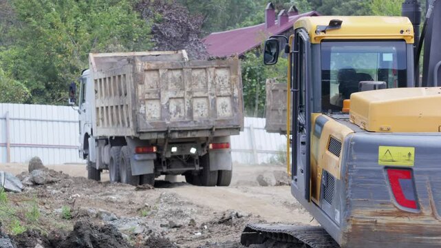 a dump truck move slowly around a construction site as it reverses. This video captures the truck's operation, showcasing construction activity and site logistics. For industry and machinery themes