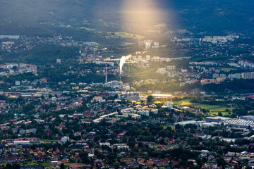 Obraz premium A ray of dawn falls on an industrial town in the mountains
