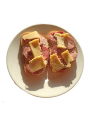 Sandwiches with sausage and cheese on a round white plate