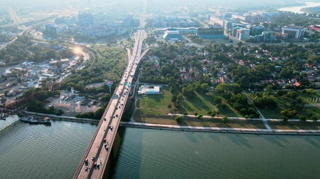 Beautiful panoramic aerial drone view to cable-stayed Siekierkowski Bridge over the Vistula river and Warsaw City skyscrapers, Poland in gold red autumn colors in November evening at sunset See Less
