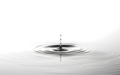 single water droplet creates ripples on calm surface, capturing moment of tranquility and reflection. concentric circles spread outward, symbolizing peace and harmony