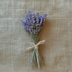 A bouquet of dried lavender tied with twine, lying on a burlap cloth