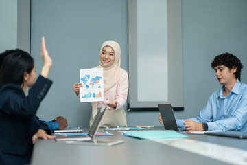 Professional presenting global data and charts during a business meeting, engaging colleagues in a collaborative discussion in a modern office.  