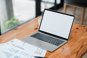 Fototapeta premium Modern Laptop on Wooden Desk with Business Documents and Pen in Bright Office Environment