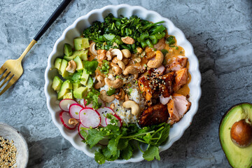 Rice bowl with salmon, avocado, radish, brocoli and curry sauce