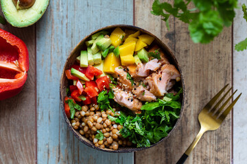 Salad bowl with salmon, lentils, mango, avocado and rocket leaves