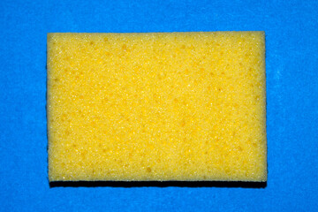 top view of a clean yellow sponge on blue background