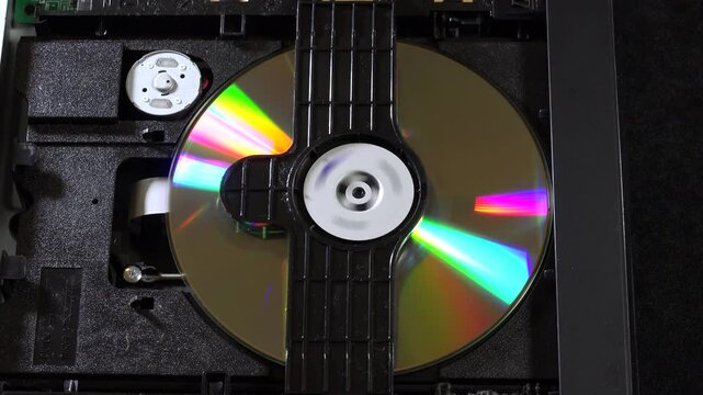 An open DVD player shows its internal components and circuitry, with the disc loading and unloading movements, seen from several angles. This image highlights the technology and design of home enterta