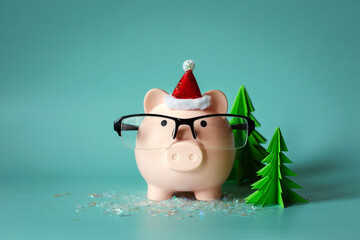 christmas concept in financial sector. Piggy bank in cap and glasses on plain background with copy space. New Year in business, economics and finance. Saving money