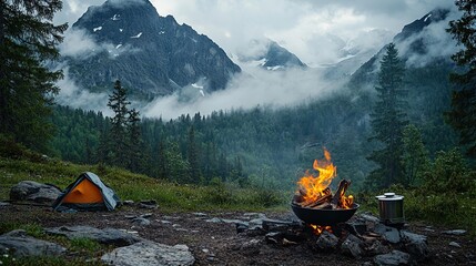 Serene campsite with a fire and mountain backdrop.