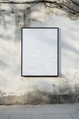 A framed blank poster set against a weathered outdoor wall, providing a rustic background for creative mockups or branding projects.