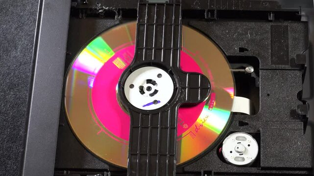 An open DVD player shows its internal components and circuitry, with the disc loading and unloading movements, seen from several angles. This image highlights the technology and design of home enterta