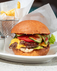Portion of american classic cheeseburger with french fries