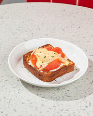 Portion of brioche breakfast toast with egg and salmon
