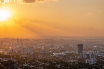 Beautiful sunset over Almaty city, bright colors of sunset sky in autumn in the city. Recognizable buildings of the city, symbols of Almaty at sunset