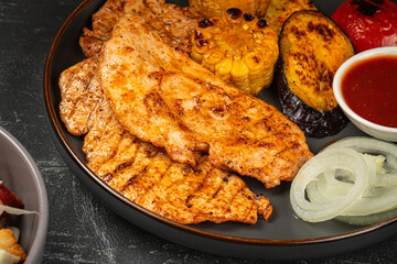 Closeup on grilled chicken breast steak with vegetables