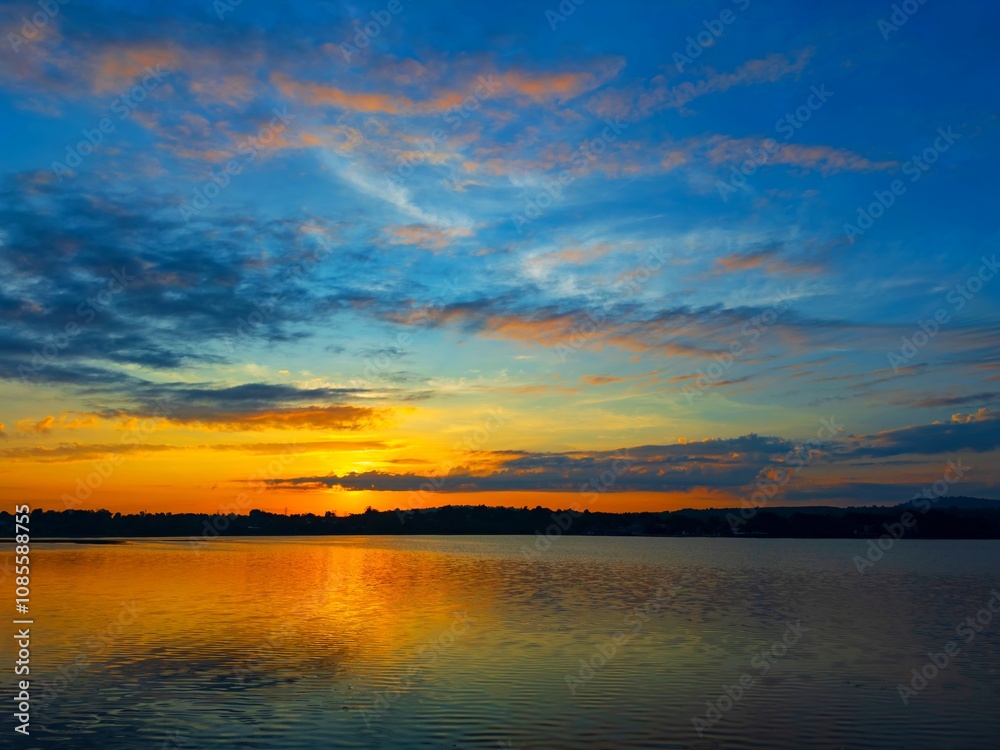 Wall mural vivid colorful color of sunset with clouds.sunset with mountain above lake reflection in water.