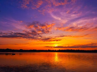 vivid colorful color of  sunset with clouds.Sunset with mountain above lake reflection in water.