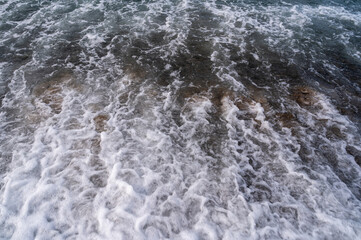 Water sea beach. Wave ocean blue. Stone texture reflection sun. Surface coast pebbles. 