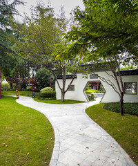 Peaceful Outdoor Pathway Surrounded by Lush Greenery and Artistic Sculptures