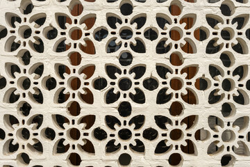 The wall features a series of intricate floral patterns, merging traditional elegance with contemporary design to enhance the architectural aesthetics of the space.