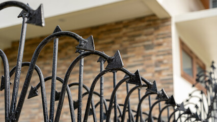 Close-up of a wrought iron fence with black arrowhead design, serving as decoration and protection...