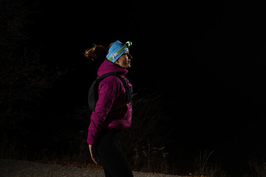  woman in warming sportswear stretching her leg while preparing for trail running in the mountain in early morning