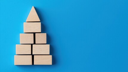 Business SEO Wood Block Concept. A simple wooden pyramid made from blocks, set against a bright blue background, creating a minimalist and playful aesthetic.